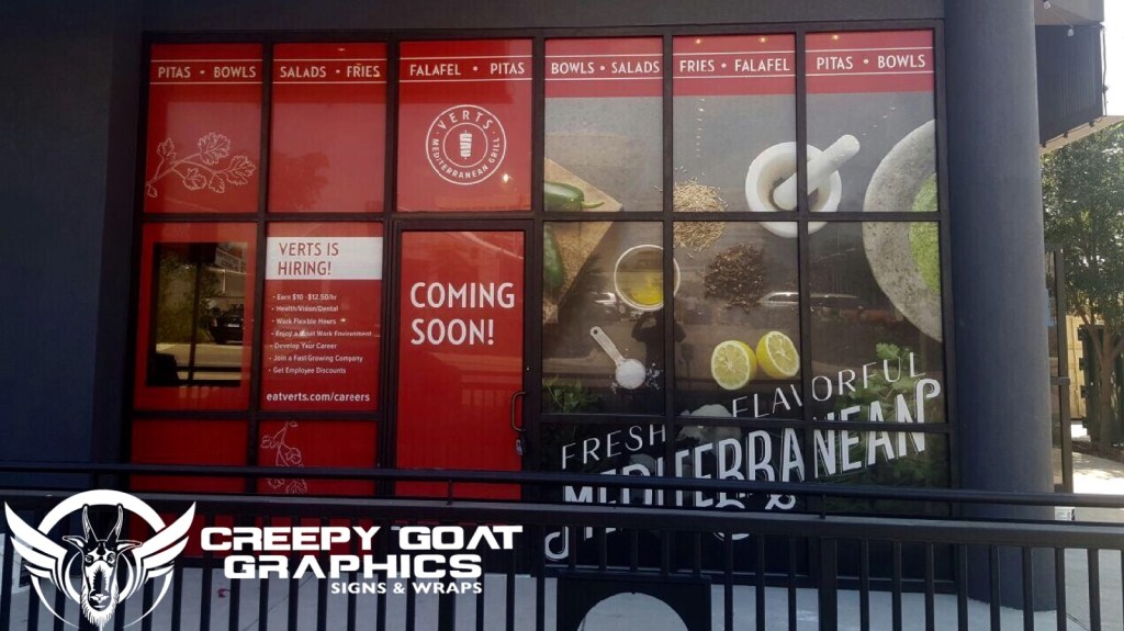 A restaurant front windows covered with perforated window vinyl, printed by Creepy Goat Graphics