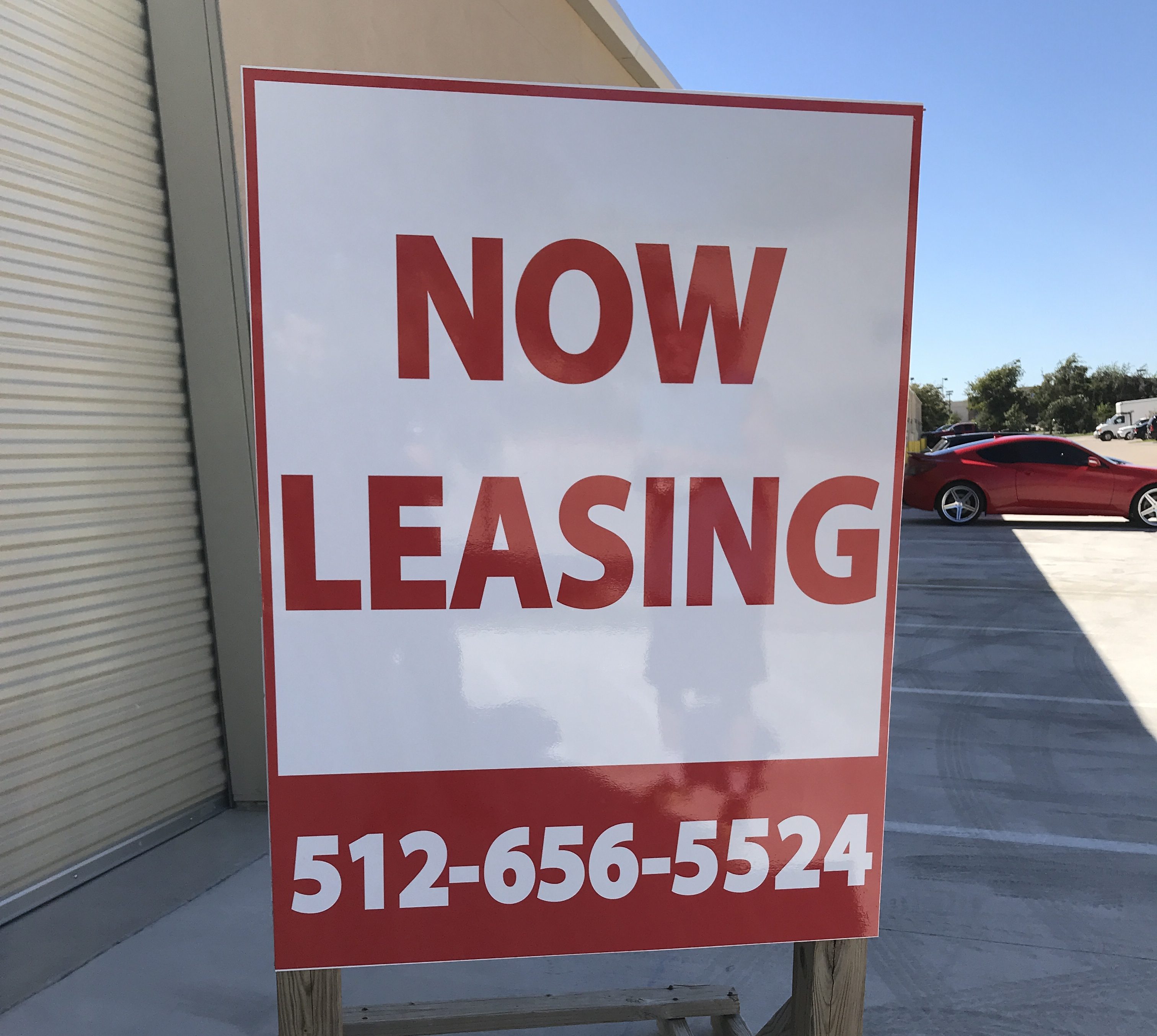 A real estate for lease sign placed on post and panel